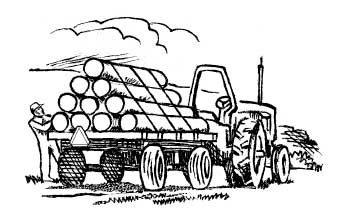 Person securing load of logs on trailer