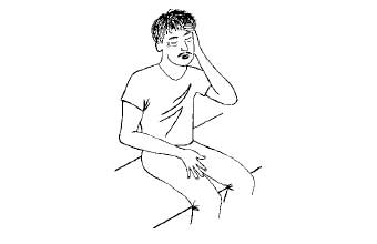 Person sitting on bench holding head suffering from heat exhaustion