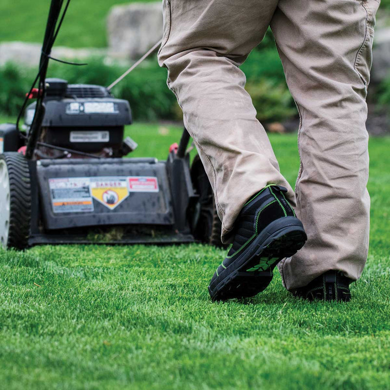 Person wearing black and green Kujo Yardwear Yard Shoes while mowing a lawn