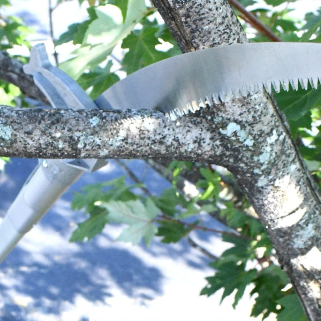 13 inch pole saw being used to saw through a large tree branch.