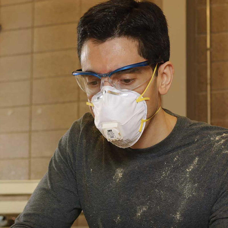 man wearing particulate respirator working in a wood shop