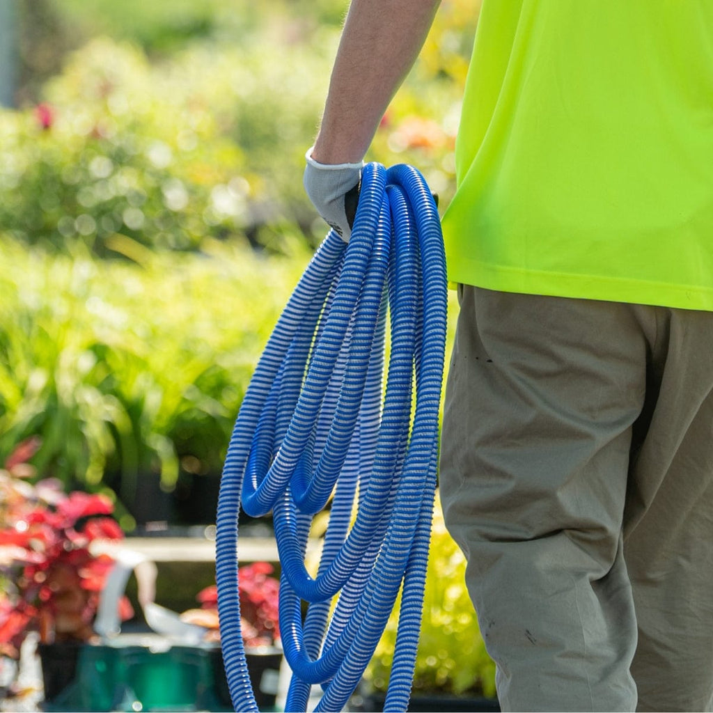 Plant nursery professional carrying a lightweight, blue water hose.
