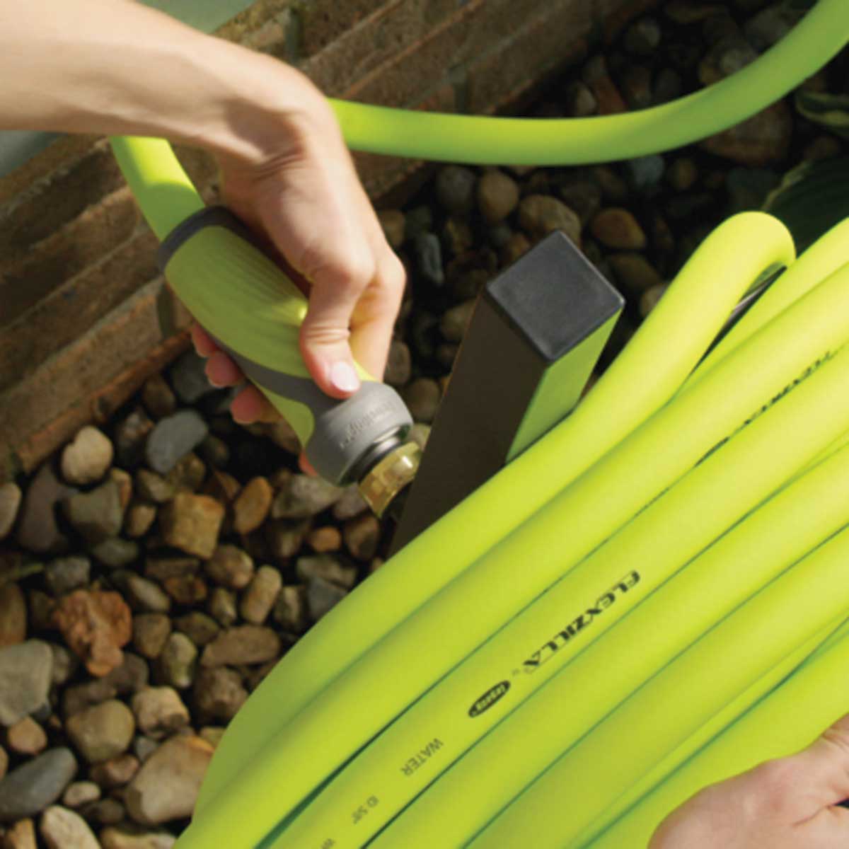 Flexzilla water hose being connected to a water spigot.