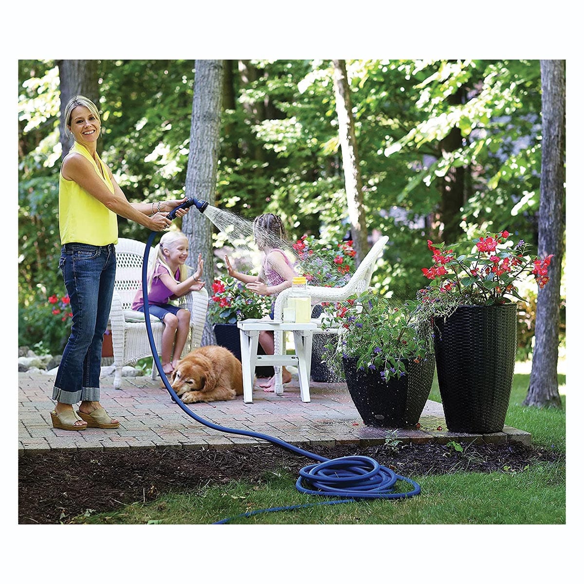 Woman watering plants with professional blue water hose