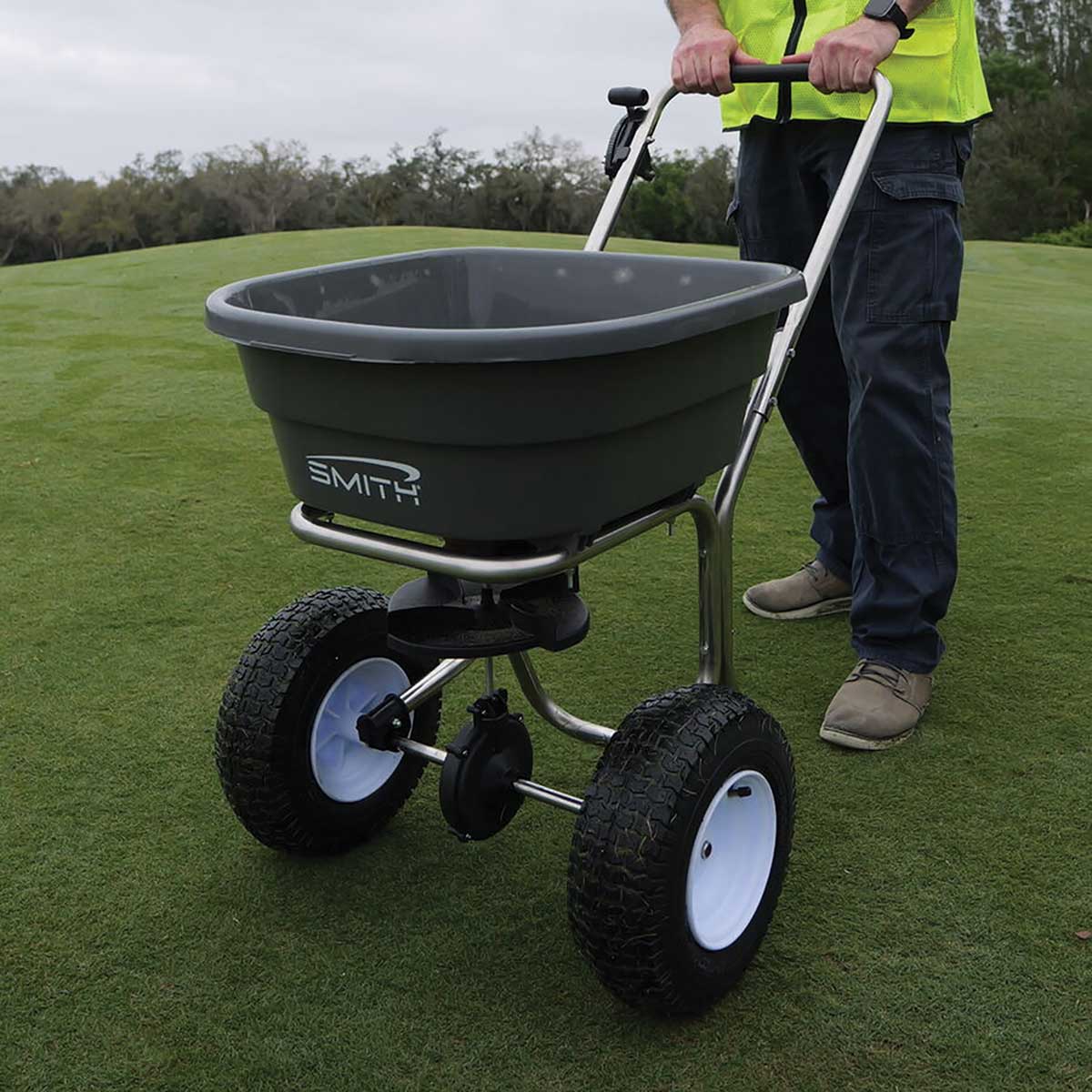 SMITH® SB80SL 80 lb Stainless Steel Push Spreader being used on a large green