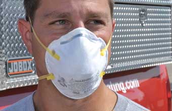 Man wearing disposable paper respirator mask