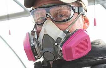 Man wearing a half-mask respirator and safety goggles