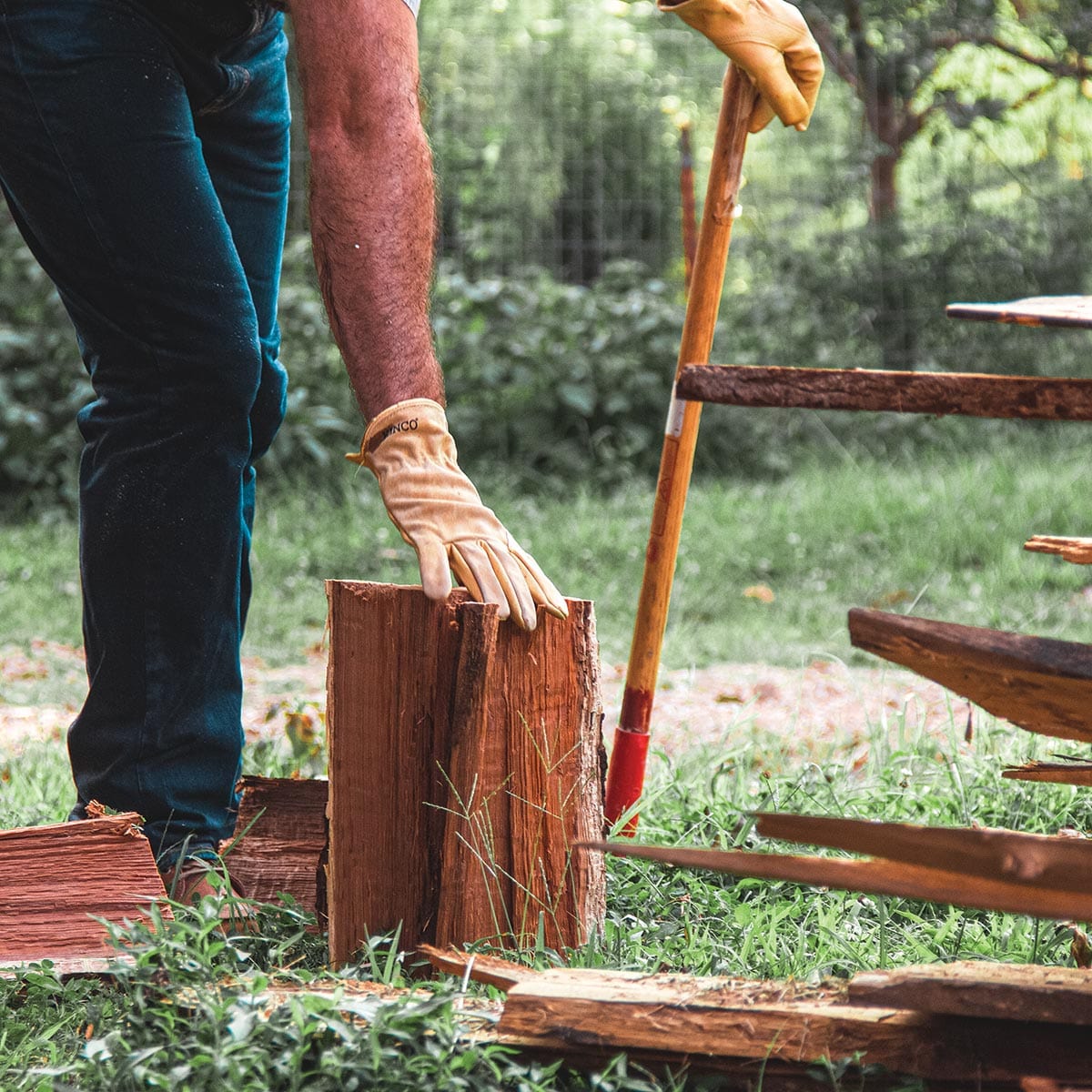 Man wearing Kinco leather driver gloves while splitting firewood