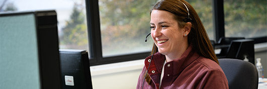 Smiling customer service rep speaking on a phone headset