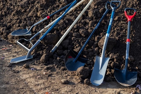 Set of professional-grade tools in a dirt pile