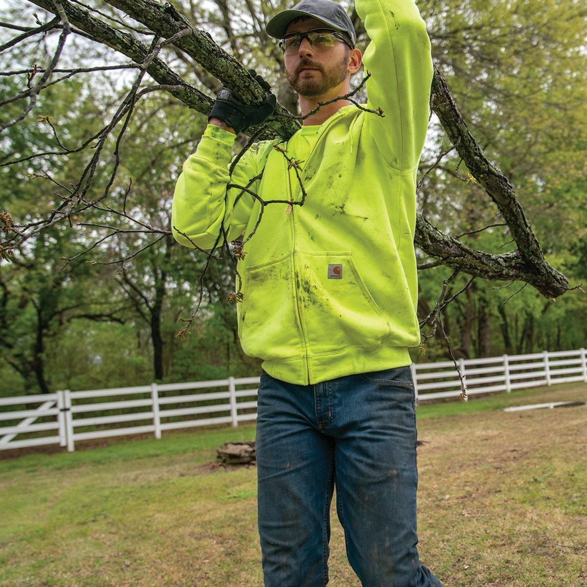 Man wearing K122 sweatshirt while carrying tree branches