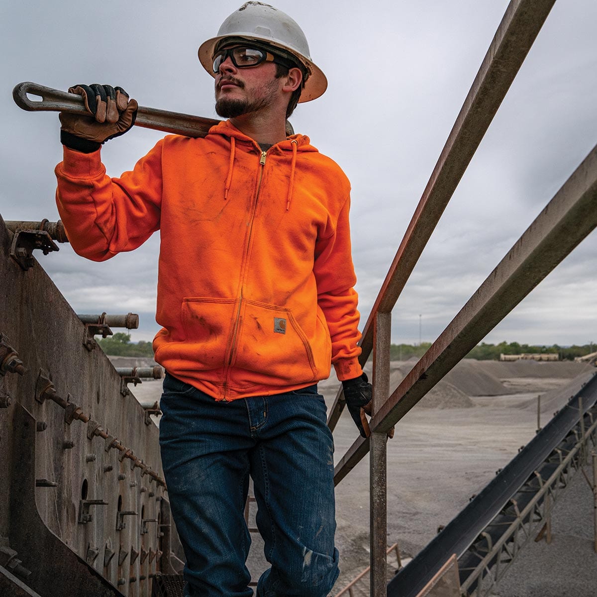 Man wearing Carhartt K122 sweatshirt climbing equipment stairs