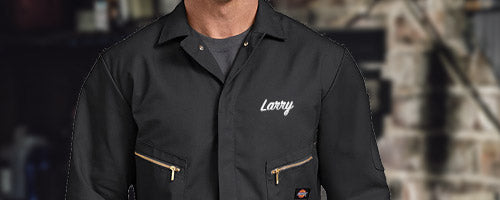 Embroidered name on chest of dark coveralls