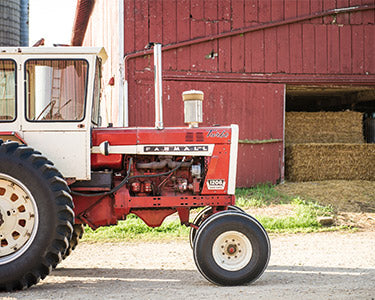 Tractor parked near a red barn