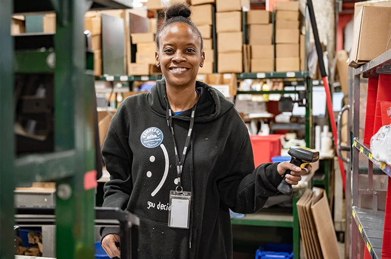 Smiling woman scanning products in a warehouse