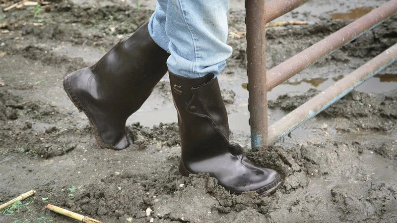 Man wearing rubber overshoes in thick mud