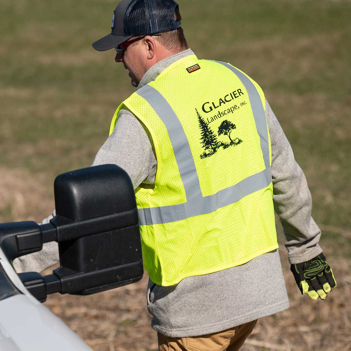 Man wearing Kishigo ANSI Class 2 Ultra-Cool 4 Pocket Hi-Vis Safety Vest with a Glacier Landscape logo on the back