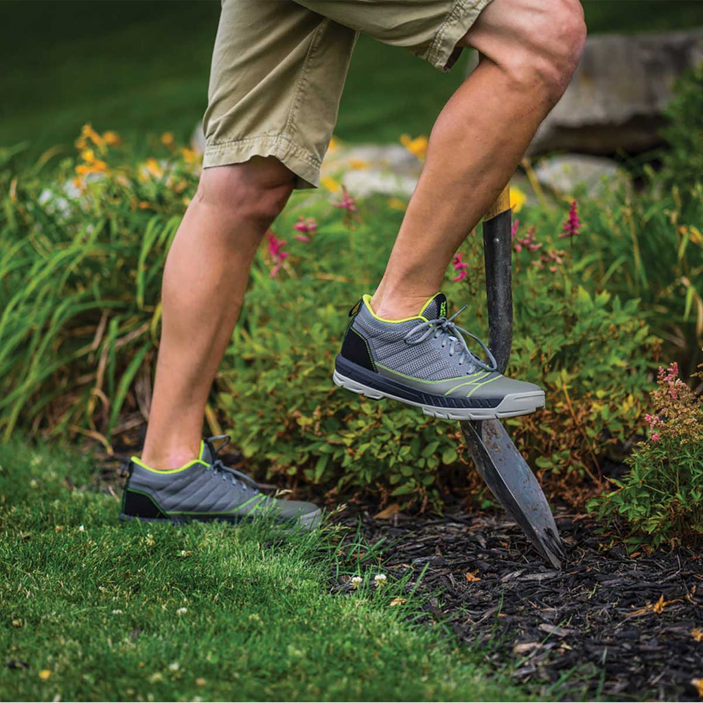 Man wearing the grey and green Kujo Yardwear Yard Shoes while using a shovel to dig a hole
