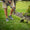 Man wearing the gray and green Kujo Yardwear Yard Shoes while trimming around a landscape bed