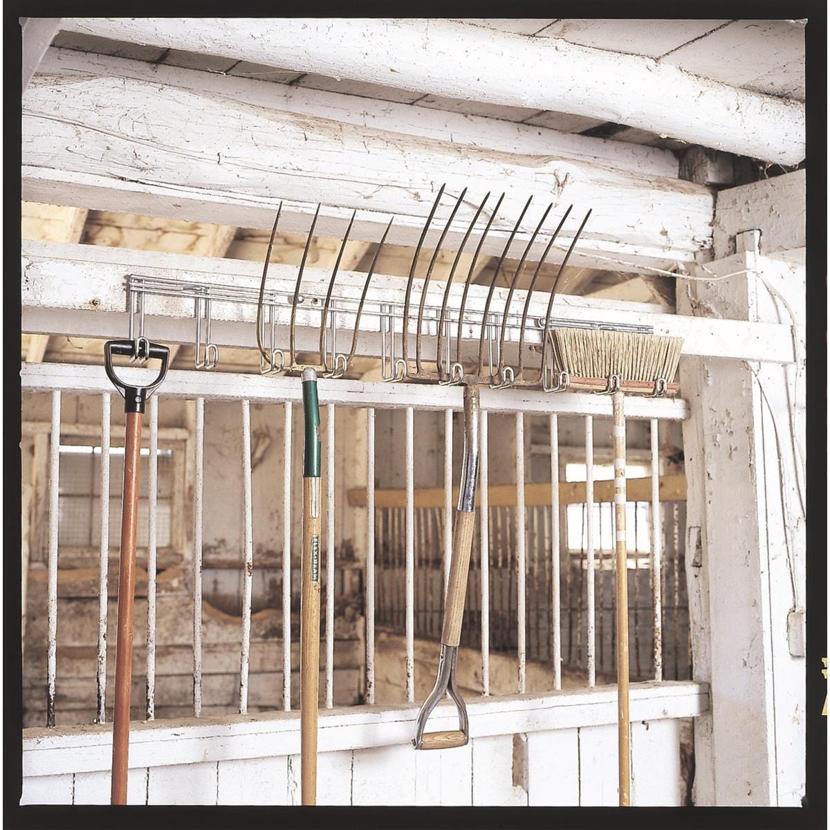 10-Hook Utility Rack hung in barn holding pitch forks and a broom